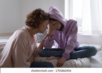 Worried parent young mom comforting depressed crying teen daughter bonding at home. Loving understanding mother apologizing or supporting sad teenage girl having psychological puberty problem concept.