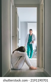 Worried Physician Running To Help Mental Disorder Female Patient Sitting On Floor In Mental Health Center Hallway