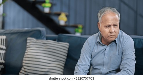 Worried retired senior man sitting alone on sofa feel sorrow abandoned anxiety at home. Unhappy Indian middle aged male grieving think lonely depressed pensive suffering health problems 
