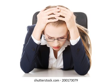 Worried, Sad Business Woman Sitting By The Table. Isolated On White.