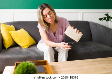 Worried And Sad Mature Woman With A Lot Of Debts Looking For More Money On Her Empty Wallet 