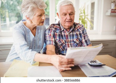 Worried senior couple checking their bills at home - Powered by Shutterstock