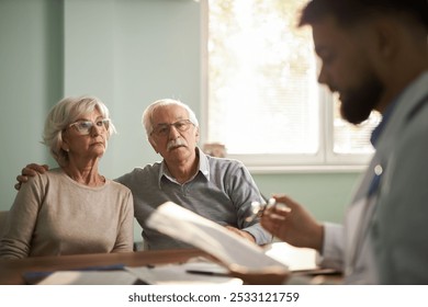 Worried senior couple talking to a doctor in the office - Powered by Shutterstock