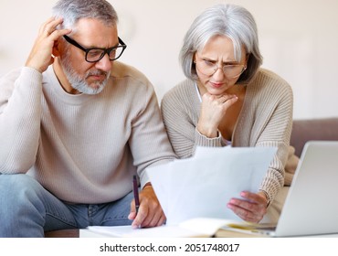 Worried Senior Family Couple Reading Financial Documents Or Notification Letter With Bad News From Bank While Paying Bills Online On Laptop, Retired Husband And Wife Having Money Problems