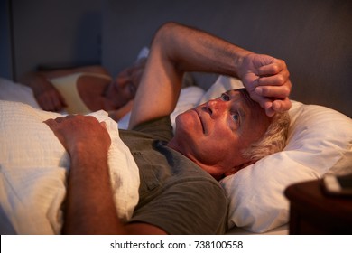 Worried Senior Man In Bed At Night Suffering With Insomnia