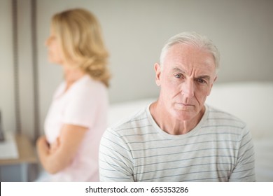 Worried Senior Man Sitting On Bed In Bedroom