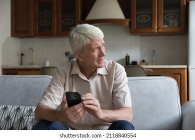 Worried senior smartphone user getting bad, concerning news message, holding mobile phone, looking away, feeling stressed, anxious, thinking over problems, sms answer - Powered by Shutterstock