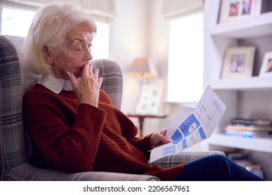 Worried Senior Woman At Home Looking At USA Energy Bill During Cost Of Living Energy Crisis