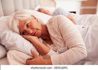 Worried Senior Woman Lying Awake In Bed