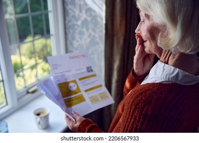 Worried Senior Woman Opening Energy Bill Concerned About Cost Of Living Energy Crisis