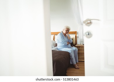 Worried senior woman sitting on bed in bedroom - Shutterstock ID 513801463