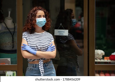 Worried Shop Assistant On Her Retail Business Door During The Pandemic Quarantine Covid 19 In Spain.