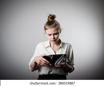 Worried Slim Woman Is Looking At An Empty Wallet