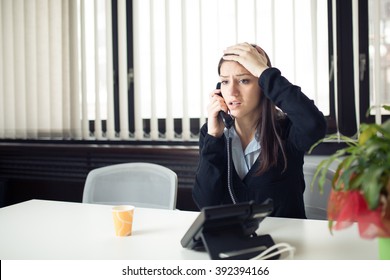 Worried Stressed Depressed Office Worker Business Woman Receiving Bad News Emergency Phone Call At Work.Looking Desperate And Confused.Disciplinary Action And Dismissal.Getting Fired.Problems At Work