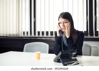 Worried Stressed Depressed Office Worker Business Woman Receiving Bad News Emergency Phone Call At Work.Looking Desperate.Manager Solves A Problem.Dismissed Woman Sitting In Office.Getting Fired.Argue