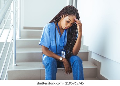 Worried and stressed doctor sitting on corridor. Shot of a female nurse suffering from a serious headache while working inside a hospital. Overworked Nurse In Scrubs Takes Coffee Break In Hospital  - Powered by Shutterstock