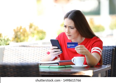 Worried Student Paying Online With Credit Card Sitting In A Coffee Shop Terrace