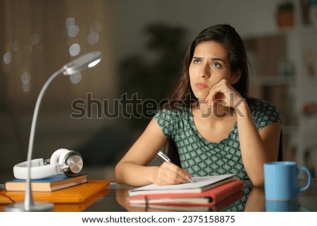 Worried student thinking trying to write a work in the night at home
