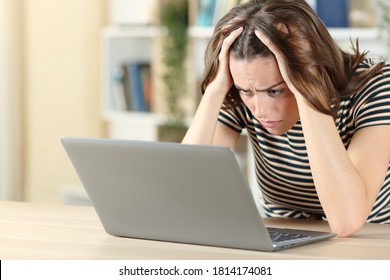 Worried Teen Checking Laptop Content On A Desk At Home