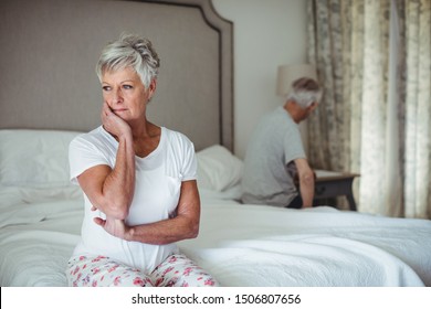 Worried and thoughtful senior woman sitting in bed room