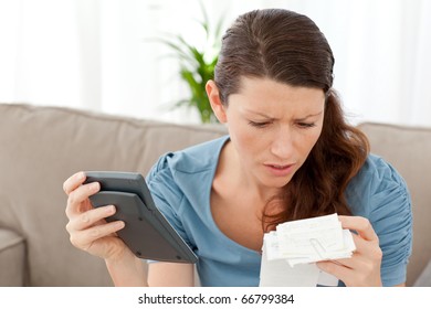 Worried Woman Calculating Her Bills In The Living-room At Home