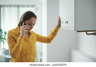 Mujer preocupada llamando a un servicio de emergencia por avería de calderas usando su smartphone