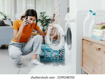 Worried woman calling a repair service, the washing machine is broken