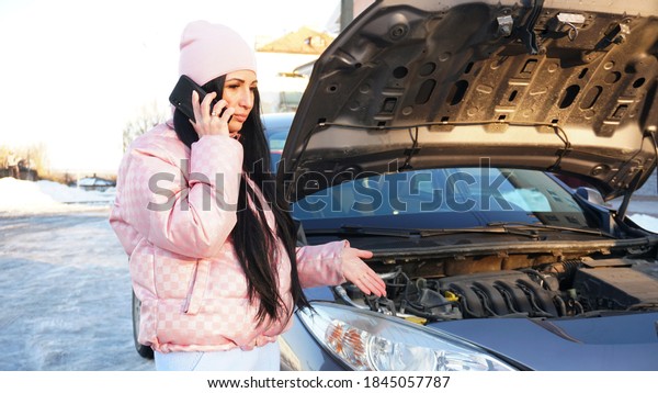 Worried woman calls car repair service near the\
broken car                        \
