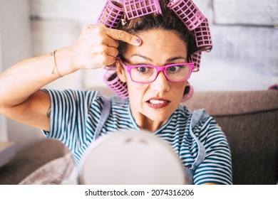 Worried Woman Check Skin Wrinkles And Eyelid. Aging And Anti Age Adult Female People Concept. Curlers On Hair. Pretty Lady Looking Herself In The Mirror At Home Making Beauty