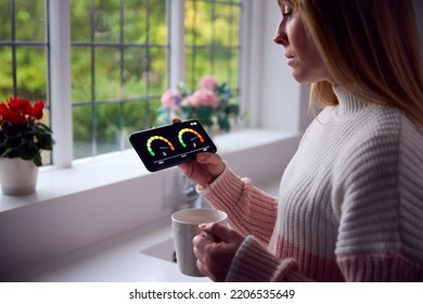 Worried Woman Looking At Smart Meter In Kitchen At Home During Cost Of Living Energy Crisis - Shutterstock ID 2206535649