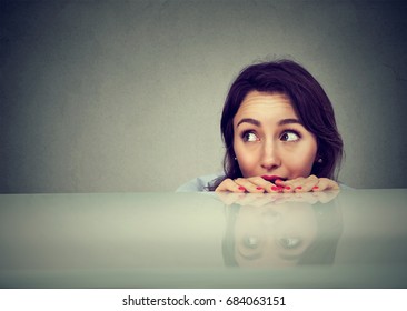 Worried Woman Looking At Something Peeking From Under The Table 