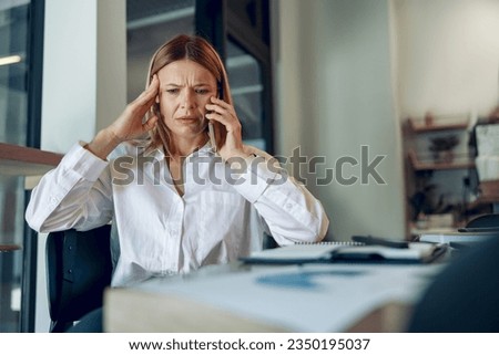 Worried woman manager makes business call and listens client claim while sitting in modern office
