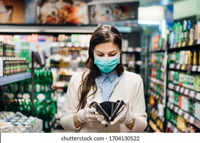 Worried Woman With Mask Groceries Shopping In Supermarket Looking At Empty Wallet.Not Enough Money To Buy Food.Covid-19 Quarantine Lockdown.Financial Problems Anxiety.Unemployed Person In Money Crisis