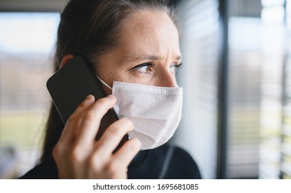 Worried Woman With Telephone And Face Masks Indoors At Home, Corona Virus Concept.