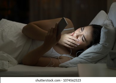 Worried Woman Watching Bad Online Content In A Smat Phone Lying On A Bed In The Night At Home