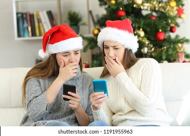 Worried Women Reading Bad News In Christmas Sitting On A Couch In The Living Room At Home