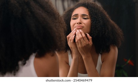 Worried young beautiful African American woman sad ethnic girl looking in mirror stressed about facial wrinkles problem acne frustrated upset touching face dry sensitive skin care facial blackheads - Powered by Shutterstock