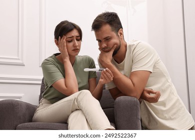 Worried young couple with pregnancy test at home - Powered by Shutterstock