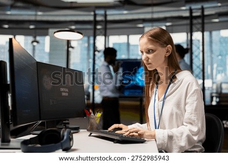 Worried young female programmer debugging code in office, looking for solutions to fix errors on screen. Frowning intern reviewing error logs at PC, trying to to resolve critical glitches