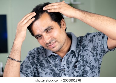 Worried Young Man Checking White Hairs Or Hair Loss By Looking Camera - Concept Of Alopecia , Haircare And Dandruff Problem