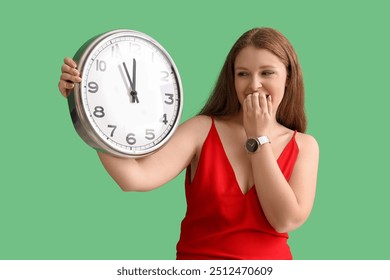 Worried young woman with clock on green background. Deadline concept - Powered by Shutterstock