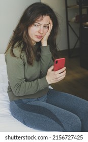 Worried Young Woman Feeling Anxiety, Holding Phone,looking Into Distance Indoor.Waiting For Call,thinking About Life,relationships Problem,unexpected Pregnancy,experiencing Grief, Heartbreak.Vertical