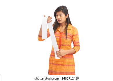 Worried Young Woman Looking At A Store Receipt 