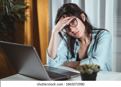 Worried young woman sitting at home desk with laptop, thinking of problems. Pensive unmotivated lady looking away, feeling lack of energy, doing remote freelance tasks at home. Overtime work concept - Shutterstock ID 1865072980