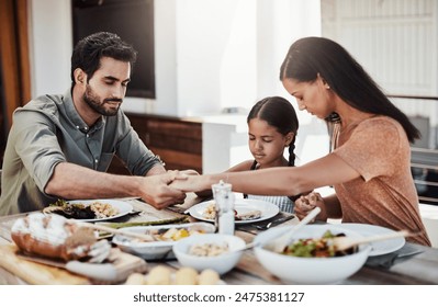 Worship, family and food at table for faith, gratitude and praying together at home. Holding hands, parents and child in dining room for lunch, support and healthy meal in afternoon for Christianity - Powered by Shutterstock