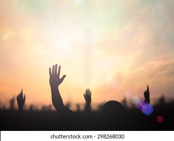 Worship God Concept: Silhouette Christian People Hand Rising Over Blurred Cross On Spiritual Light Background