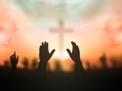 Worship God concept: Silhouette person hands reaching over blurred cross autumn sunset background, a Photo by Jacob_09