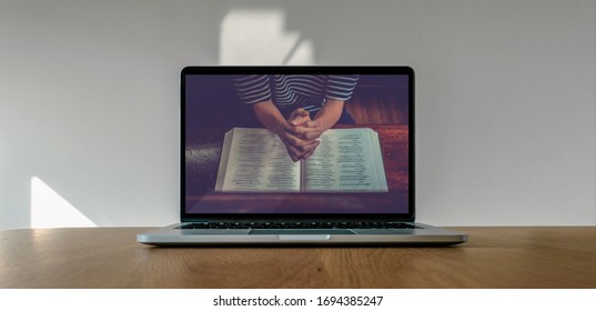 Worship from home, Online live church for sunday service, Laptop screen with close up prayer hands, quarantine for Covid 19 situation - Shutterstock ID 1694385247