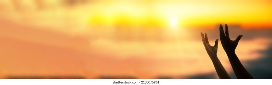 Worship and prayer banner. Christian worship and praise. A young woman is praying and worshiping in the evening.  - Shutterstock ID 2133075961