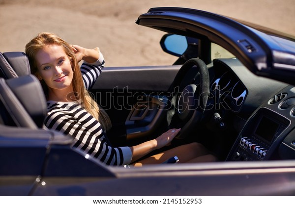 It was worth every penny. Shot of a young woman\
driving in a sports car.